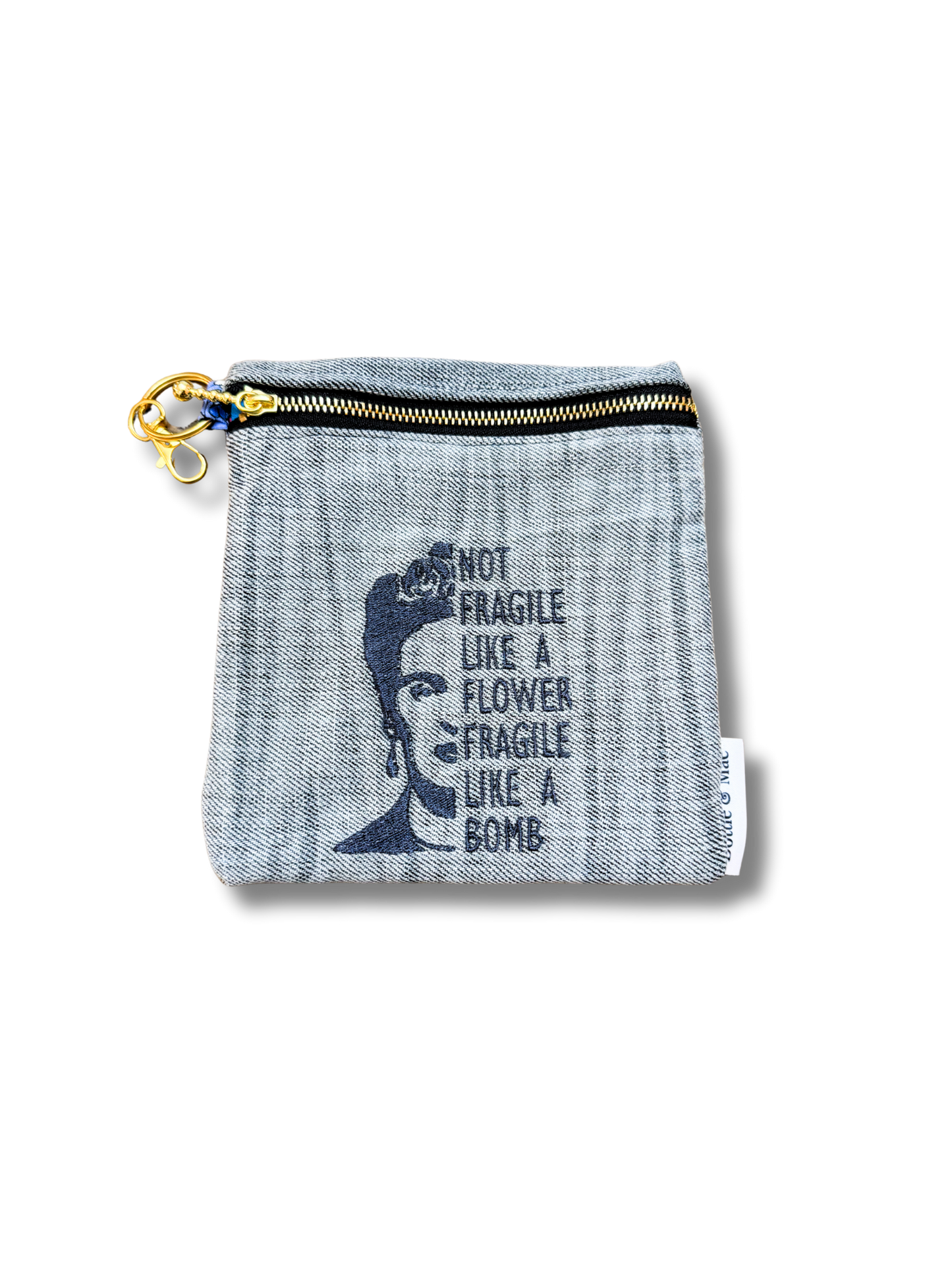 denim pouch with frieda kahlo quote "not fragile like a flower fragile like a bomb" on white background