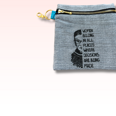 Denim pouch with embroidered design and text on a white background